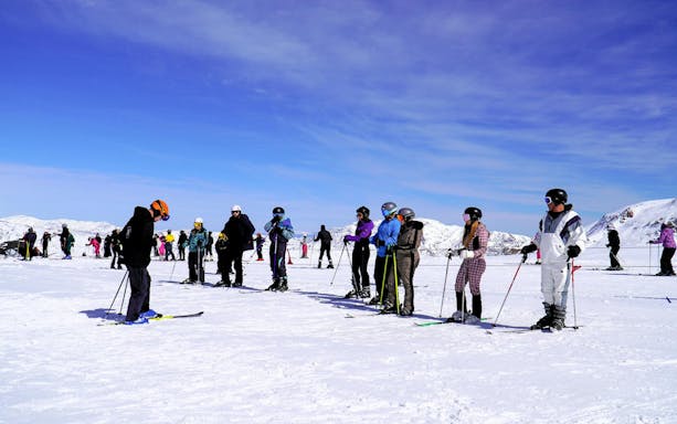 Skiers preparing on snowy slopes at Valle Nevado ski resort, Chile.