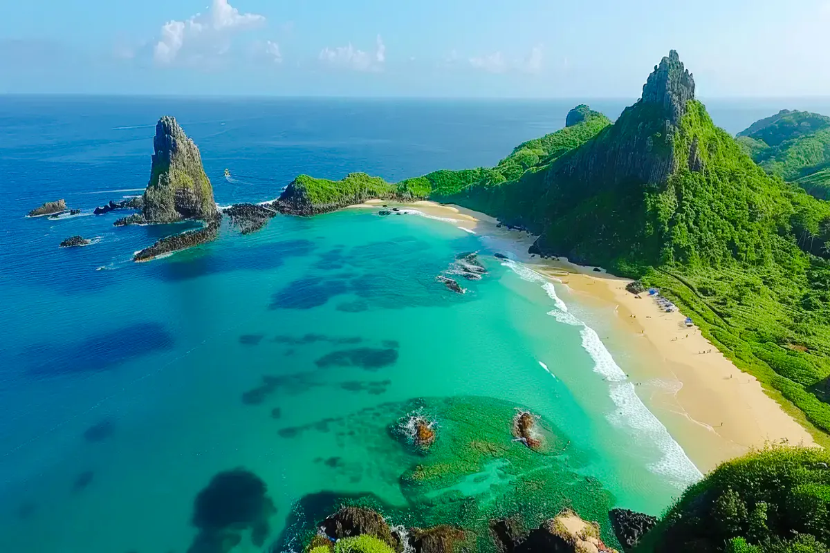 Aerial view of Sancho Beach and Porcos Bay with turquoise waters and lush cliffs, Noronha Island tour.