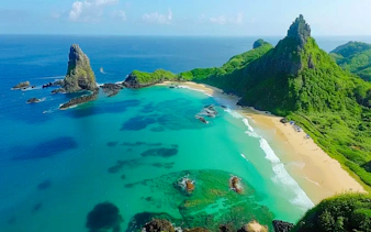 Aerial view of Sancho Beach and Porcos Bay with turquoise waters and lush cliffs, Noronha Island tour.
