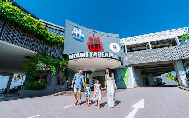 Family walking at Mount Faber Peak entrance, Singapore, with cable car signs above.