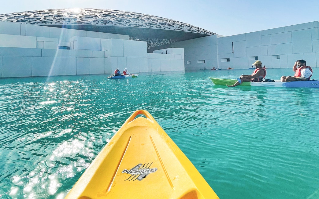 Kayakers paddling near Louvre Abu Dhabi's dome on a guided tour.