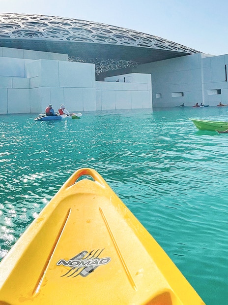 Kayakers paddling near Louvre Abu Dhabi's dome on a guided tour.