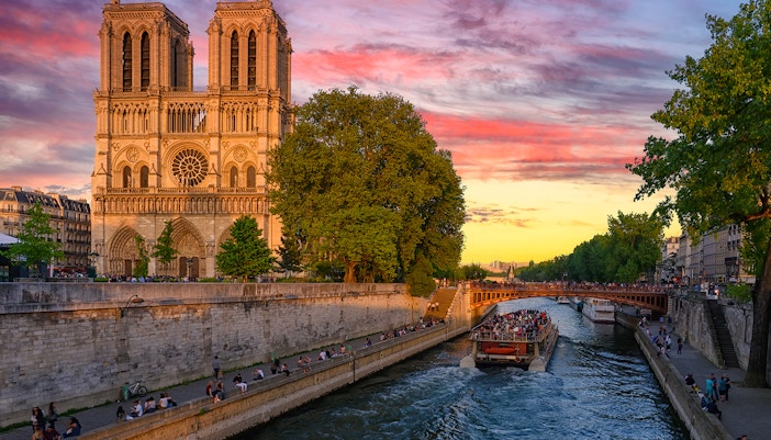 Seine River cruise with sunset view of Notre Dame Cathedral in Paris.