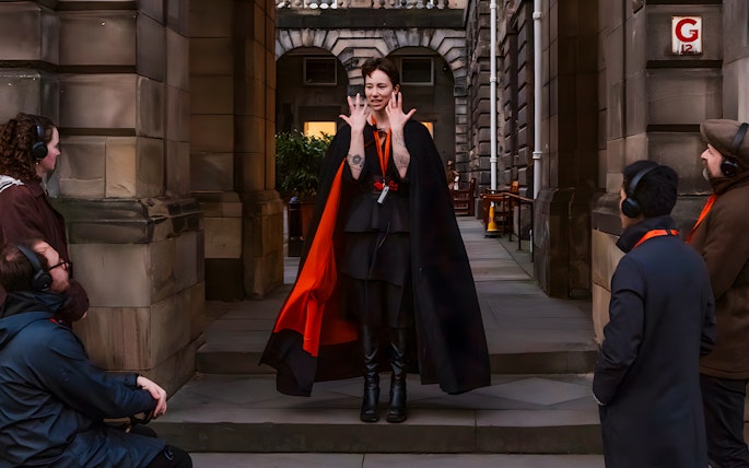 Guide leading Edinburgh Royal Mile ghost tour with guests using audio guides.