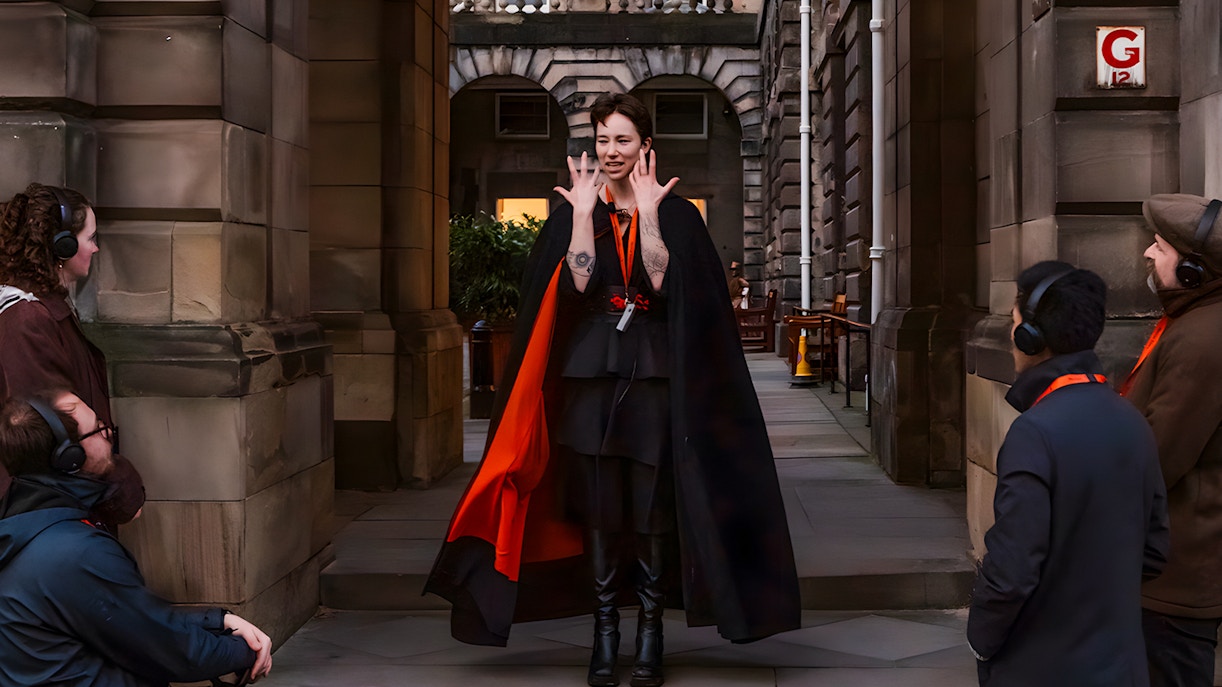 Guide leading Edinburgh Royal Mile ghost tour with guests using audio guides.