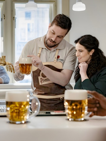 Bartender explaining Czech beer pouring technique to a visitor.