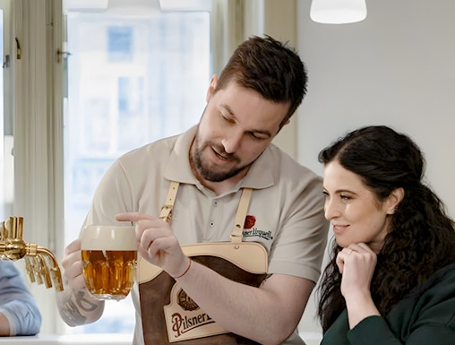 Bartender explaining Czech beer pouring technique to a visitor.