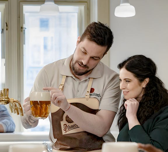 Bartender explaining Czech beer pouring technique to a visitor.
