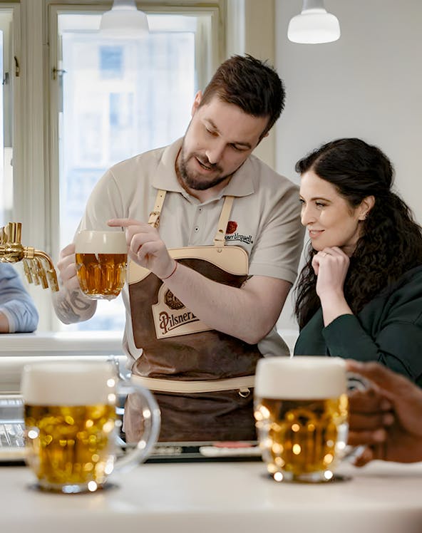 Bartender explaining Czech beer pouring technique to a visitor.