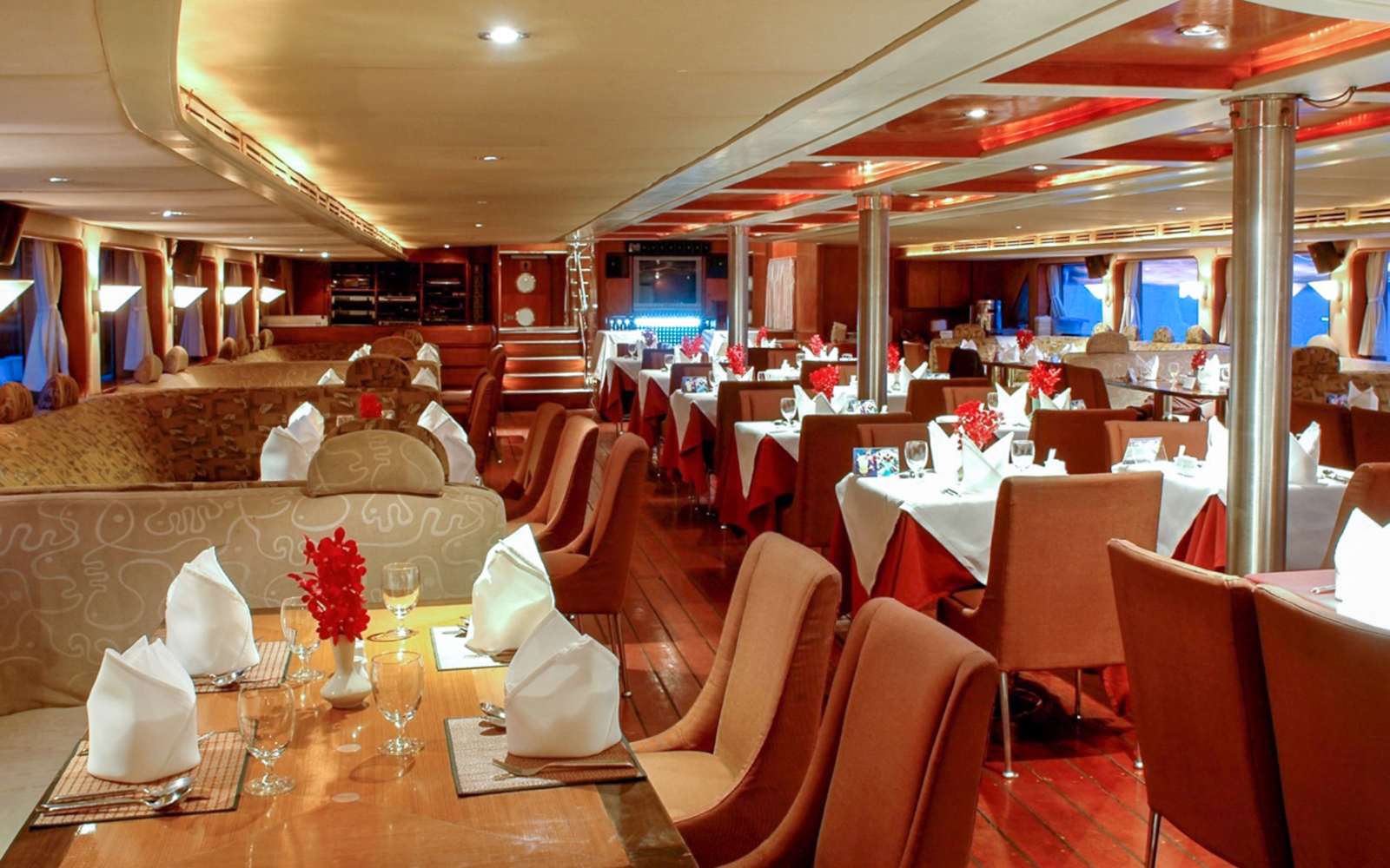 Elegant dining setup on the Grand Pearl Dinner Cruise with tables and chairs.