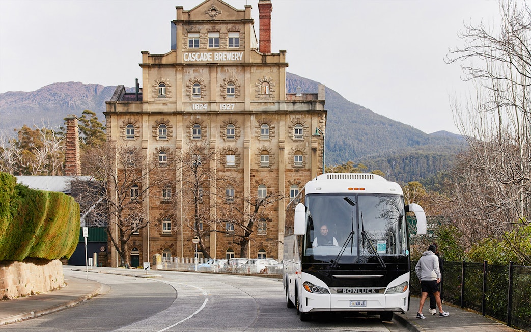 Bus parked near Cascade Brewery with Mt Wellington in the background.