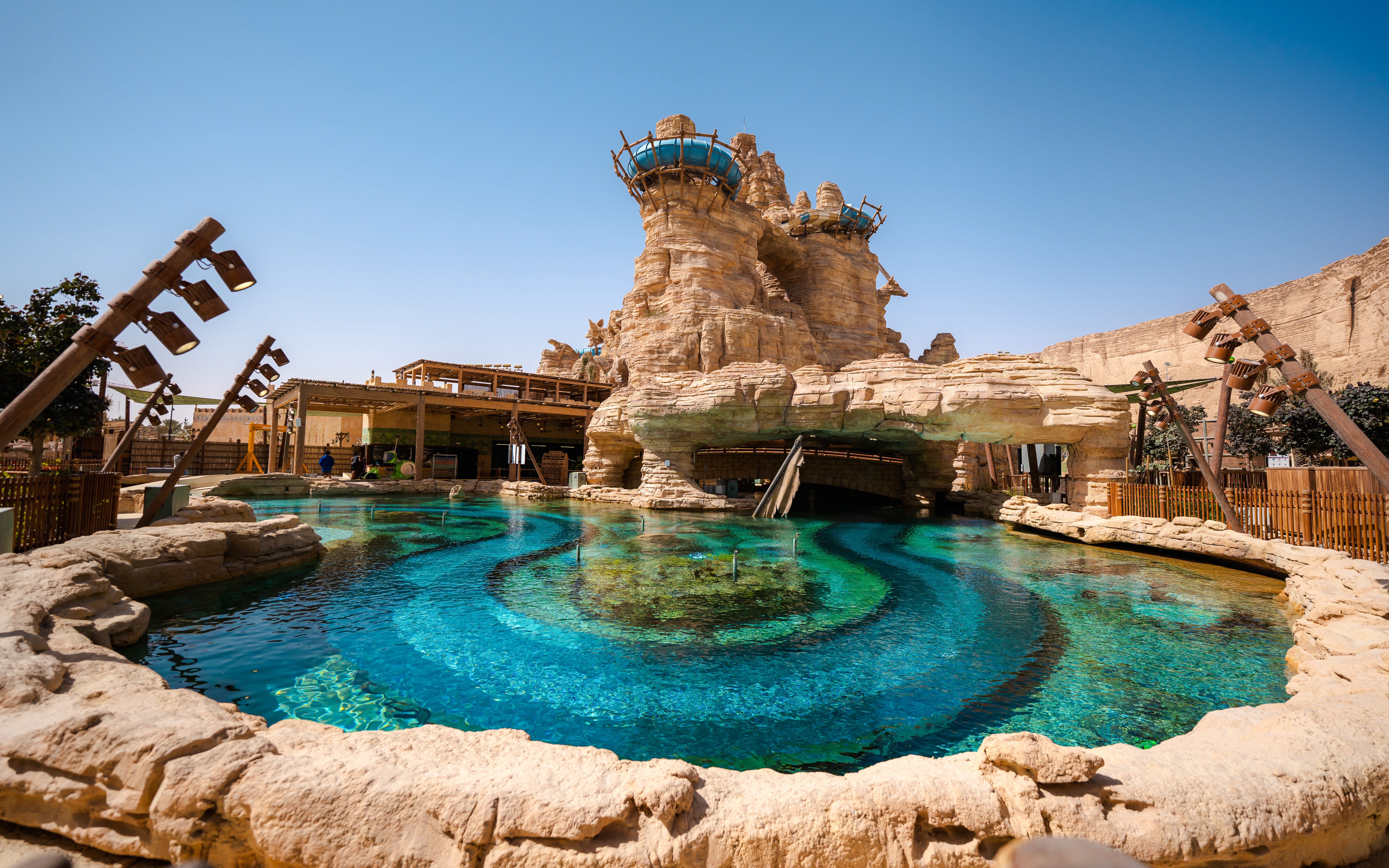 Aquarabia Qiddiya ride with rocky structure and clear blue water.