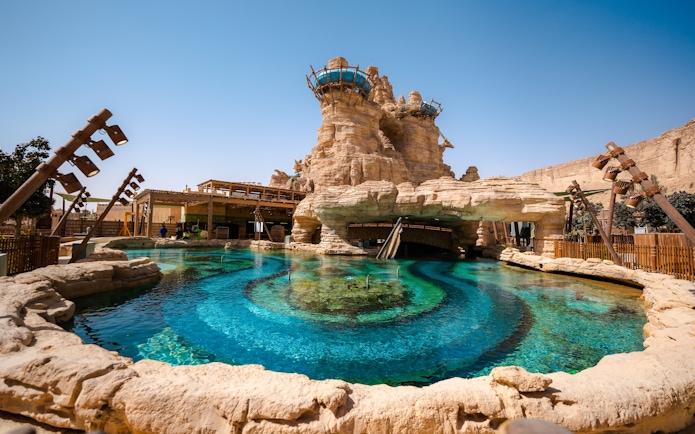 Aquarabia Qiddiya ride with rocky structure and clear blue water.
