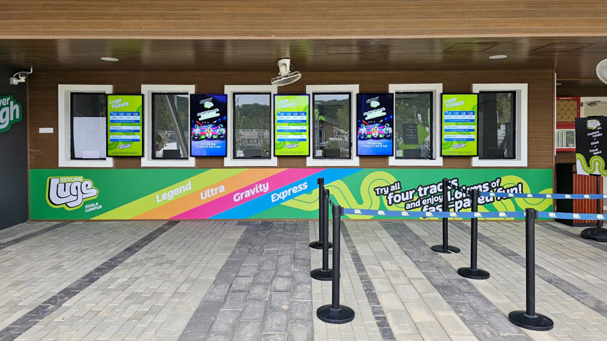 Ticket counter at Skyline Luge Kuala Lumpur with colorful signage and track options.