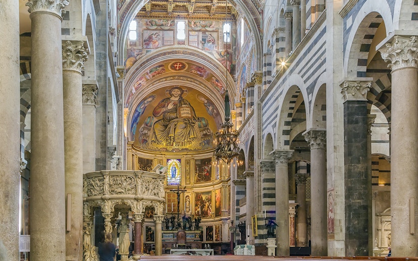 Interior view of Pisa Cathedral, Italy, featuring ornate frescoes and columns.