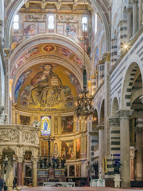 Interior view of Pisa Cathedral, Italy, featuring ornate frescoes and columns.