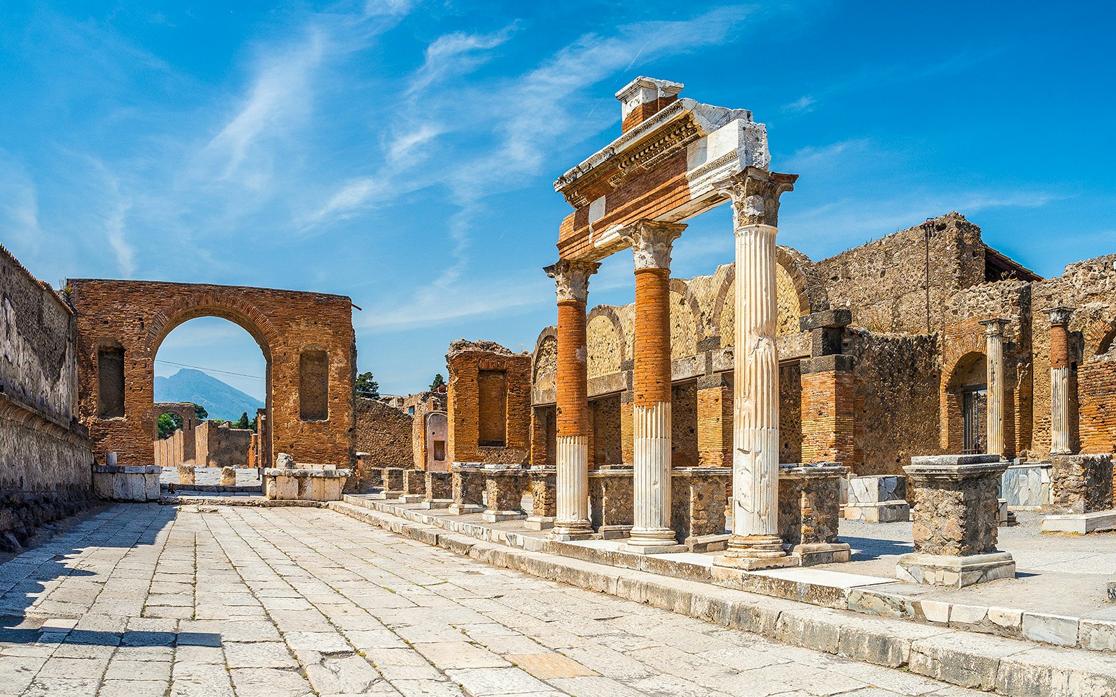 Pompeii Forum ruins with Mount Vesuvius backdrop on guided tour from Naples or Sorrento.