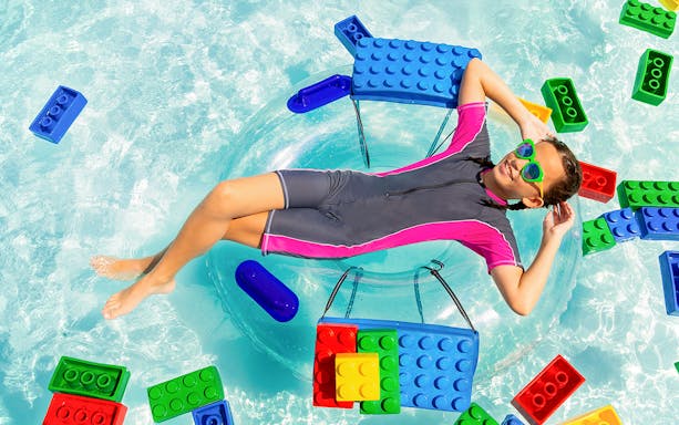 Girl floating on a tube surrounded by LEGO bricks at LEGOLAND® Malaysia water park.