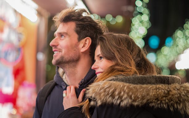Guests enjoying Szentendre Christmas Market with festive lights in the background.