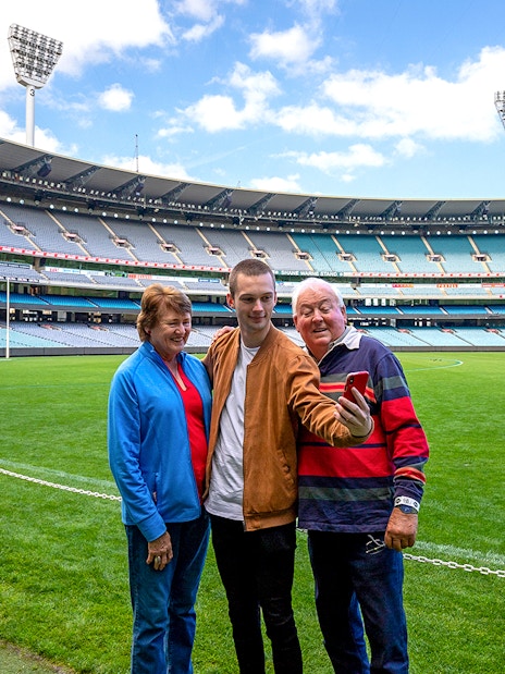 Visitors taking a selfie on the field during a tour of the Melbourne Cricket Ground.