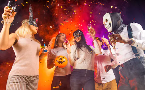 Partygoers in costumes celebrating at Bran Dracula's Castle Halloween event.