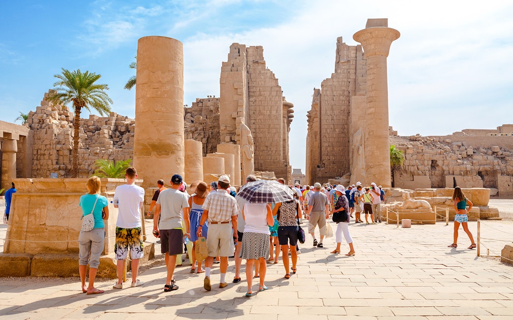 Tourists exploring ancient ruins at Luxor Temple, Egypt.