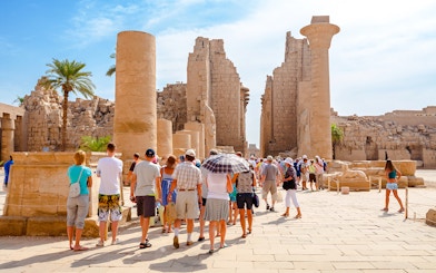 Tourists exploring ancient ruins at Luxor Temple, Egypt.