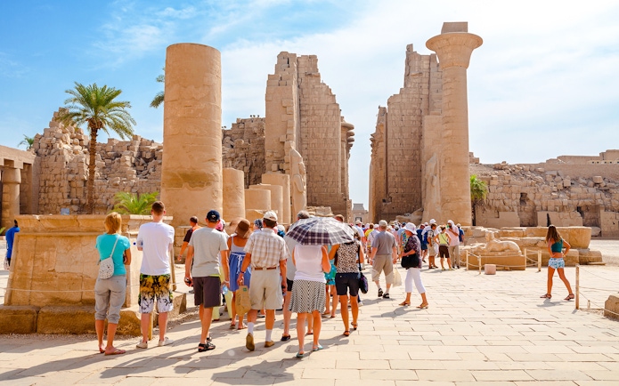 Tourists exploring ancient ruins at Luxor Temple, Egypt.