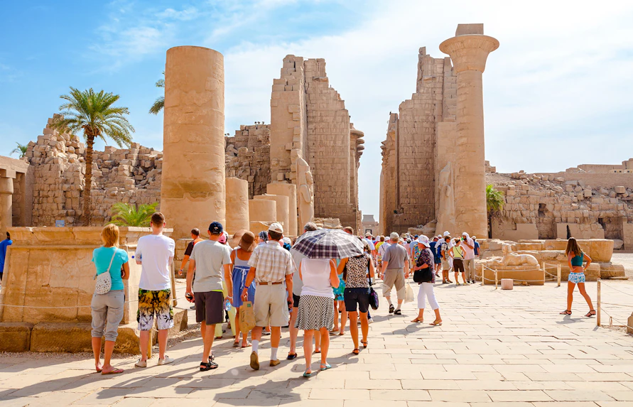 Tourists exploring ancient ruins at Luxor Temple, Egypt.