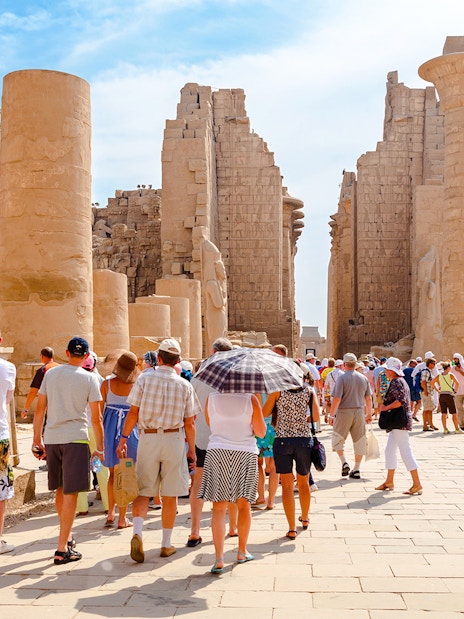 Tourists exploring ancient ruins at Luxor Temple, Egypt.