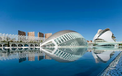 Hemisfèric and Palau de les Arts in City of Arts and Sciences, Valencia, reflected in water.