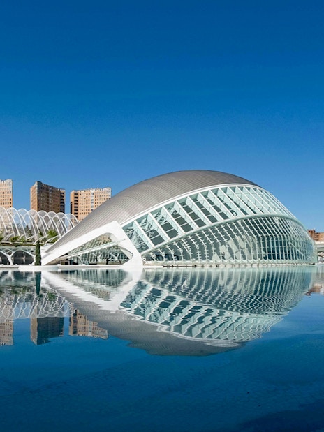 Hemisfèric and Palau de les Arts in City of Arts and Sciences, Valencia, reflected in water.
