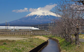 Bullet train Shinkansen passing with Mount Fuji in the background, Japan.