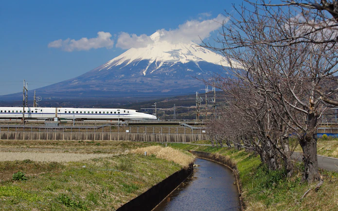 Bullet train Shinkansen passing with Mount Fuji in the background, Japan.
