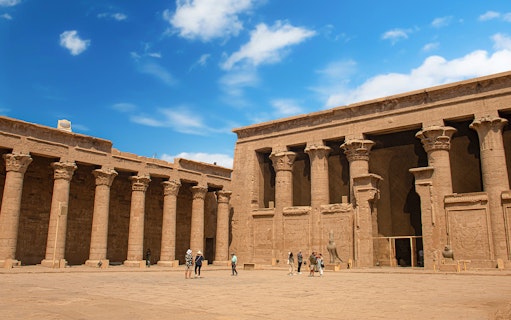 Visitors exploring the courtyard of Temple of Horus at Edfu, Egypt.