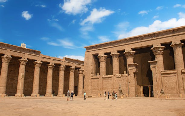 Visitors exploring the courtyard of Temple of Horus at Edfu, Egypt.