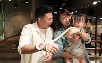 Family interacting with a snake at Just Farm Indoor Zoo Kuala Lumpur.