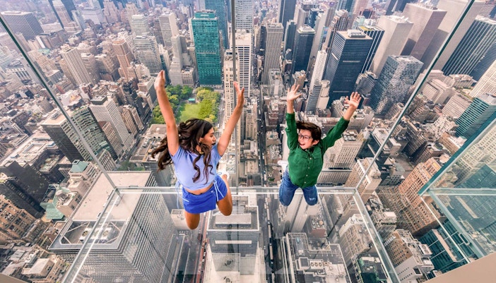 Children jumping inside all-glass skyboxes at SUMMIT One Vanderbilt, New York City.