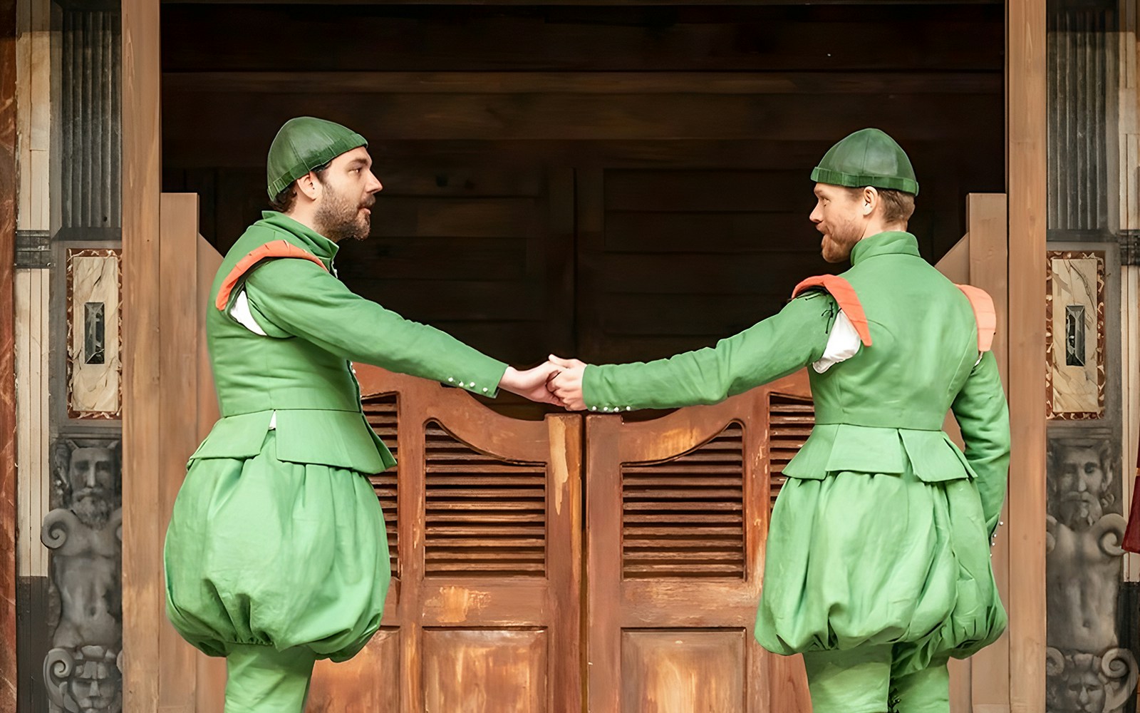 Actors in green costumes performing "The Comedy of Errors" on stage.