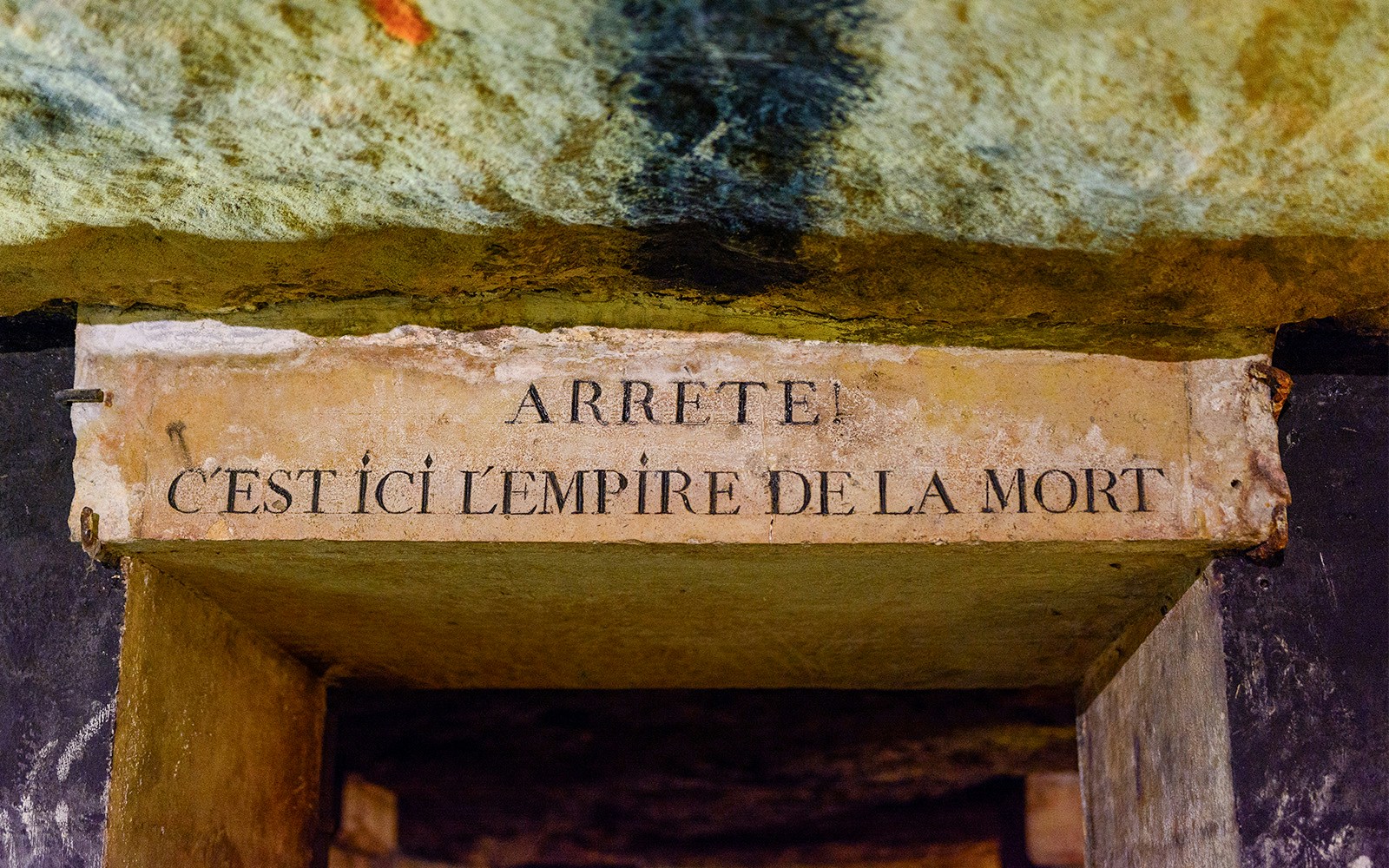 Entrance sign in the Paris Catacombs with inscription "Arrête! C'est ici l'empire de la mort.