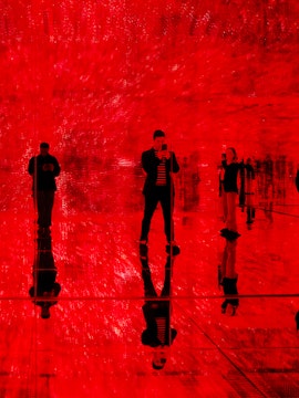 Visitors in a red-lit room at Mercer Labs: Museum Of Art & Technology exhibit.