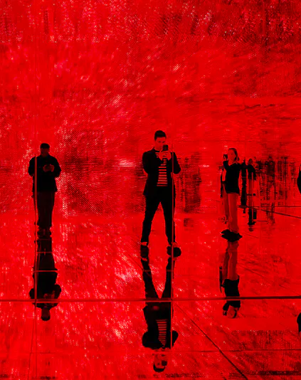 Visitors in a red-lit room at Mercer Labs: Museum Of Art & Technology exhibit.