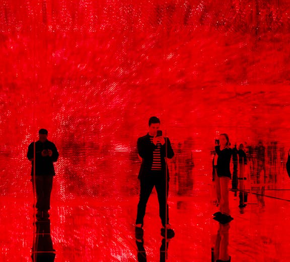 Visitors in a red-lit room at Mercer Labs: Museum Of Art & Technology exhibit.