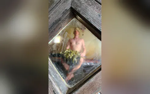 Sauna interior with person holding birch branches, Sofia heritage experience.