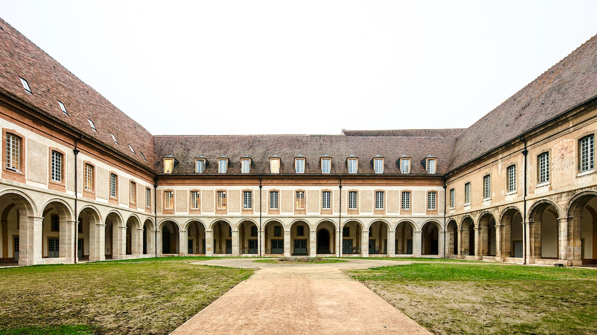 Courtyard of Abbaye de Cluny with arched walkways, Lyon, France.