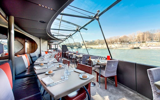 Dining tables set for a Christmas cruise on the Seine River in Paris, starting at the Eiffel Tower.