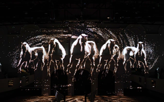 Horses in light projection at Abu Dhabi Royal Equestrian Arts show.