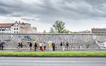 Visitors viewing colorful murals on the Berlin Wall, Germany.