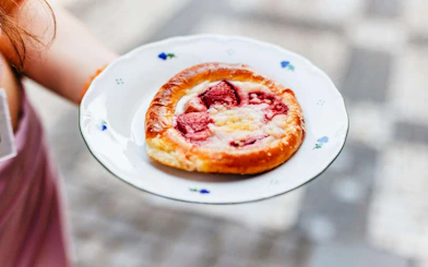 Pastry with strawberries on a plate during Prague Old Town food walking tour.