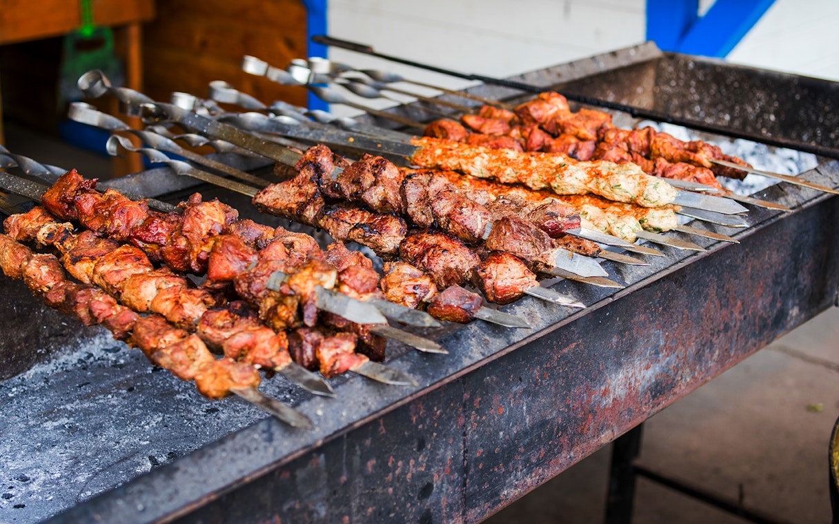 Grilled kebabs on skewers at a Dubai street food market.